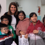 La secretaria Gisela Zamora junto a alumnos y directivos durante la entrega de lentes en las escuelas del distrito