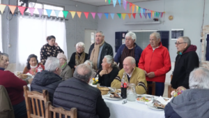 Julio Zamora junto a los socios del Centro de Jubilados La Armonía durante el almuerzo en Dique Luján